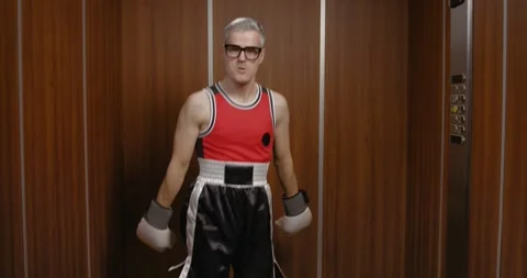 Funny nerdy boxer taking an elevator Stock Footage 308919560