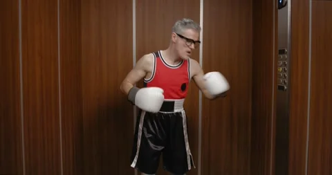 Funny nerdy boxer taking an elevator Stock Footage 308919563