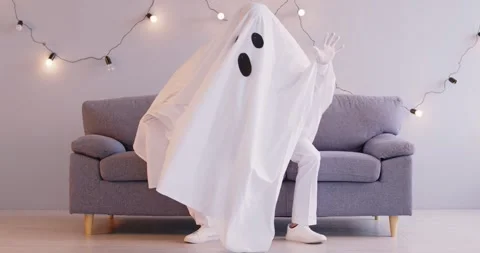 Funny person in white sheet ghost costume doing dance moves and having fun on Stock Footage 312097613