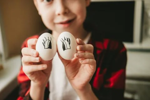 Funny picture of a boy with eggs instead of eyes. Eggs with painted eyes. Pre Foto stock