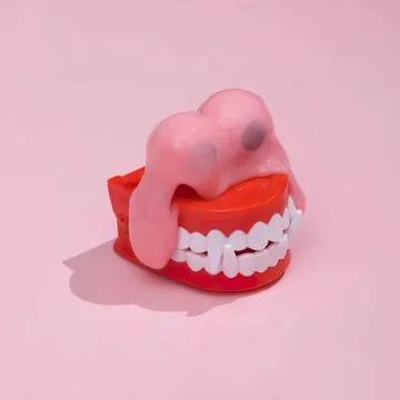 Funny pink teeth model with gums and tongue on pink background Stock Photos