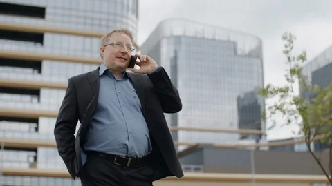 Funny plump man in suit talking by smartphone adult manager smiling on street Stock Footage 107881973