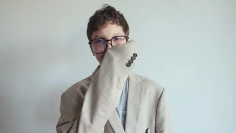 Funny portrait of a boy with glasses in a big jacket with a laptop in his hand.  Stock Footage 242082465