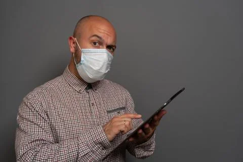 Funny Portrait of a keep working bearded man with tablet in hands in a gauze  Stock Photos