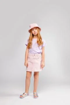 Funny red-haired long-haired girl in daily clothes (skirt, t-shirt) Stock Photos