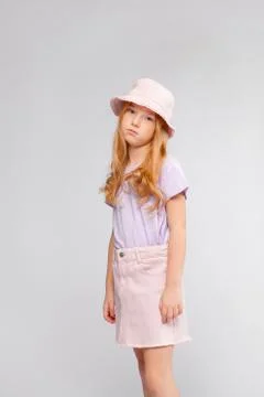 Funny red-haired long-haired girl in daily clothes (skirt, t-shirt) Stock Photos