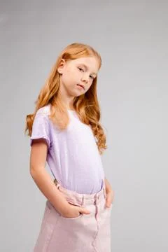 Funny red-haired long-haired girl in daily clothes (skirt, t-shirt) Stock Photos