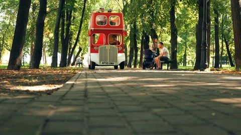 Funny Red small bus in summer park. Family Fun. Stock Footage 79637625