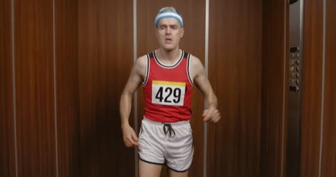 Funny runner warming up and running in the elevator Stock Footage 308919605