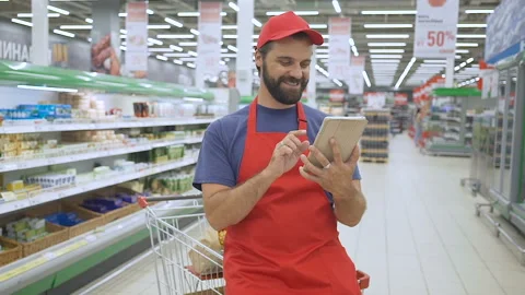 Funny sales clerk using a digital tablet in supermarket Stock Footage 93545360