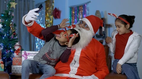 Funny Santa Claus taking selfies with young kids during Christmas celebration... Stock Footage
