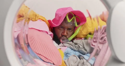Funny serious dark skinned Afro American man pretends swimming in washing Stock Footage 156632252