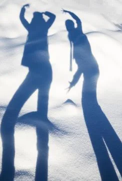 Funny shadows of two figures on white snow Stock Photos
