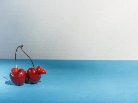 A funny shaped cherry on a blue background with space Stock Photos