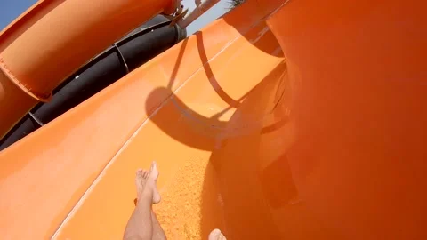 Funny slope down inside orange water slide in water park. Slow motion Stock Footage 158126161