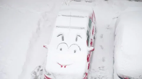 Funny smiley face emoticon drawn in the snow on a car windshield in winter Stock Footage 61929990