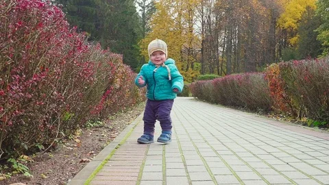 Funny smiling 1 year old boy Walking in the autumn Park at the Sunset with bread 스톡 동영상 88658069