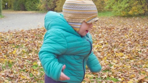Funny smiling 1 year old boy Walking in the autumn Park at the Sunset with bread Stock Footage 95365335