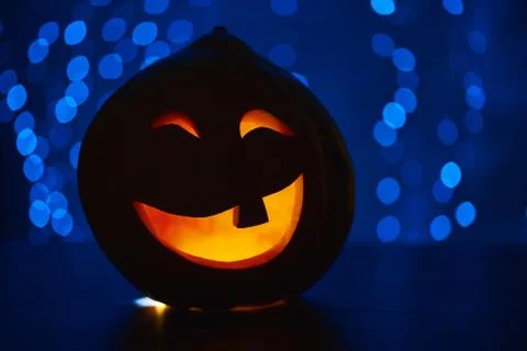 Funny smiling pumpkin with fire inside prepared for Halloween holiday. Stock Photos