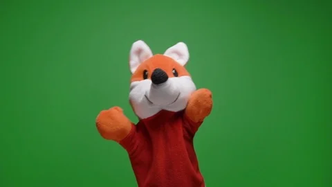 Funny soft fox doll on green background, hand with plushie glove puppet toy at Stock Footage 124576929