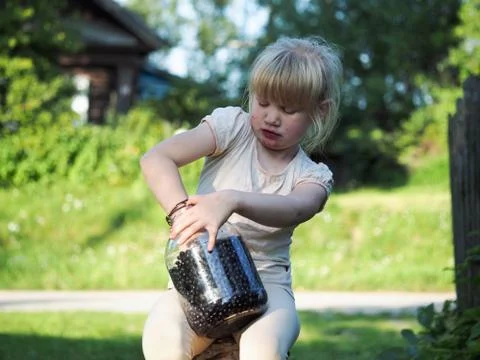 Funny soiled child eats blueberries with pleasure Stock Photos