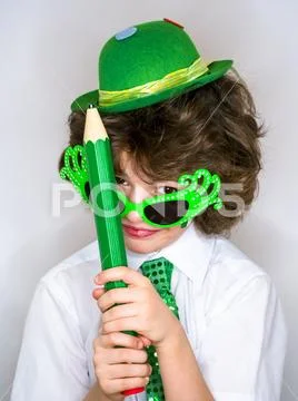 Funny St Patricks day stunning little boy wearing a green hat, carnival glass Stock Photos