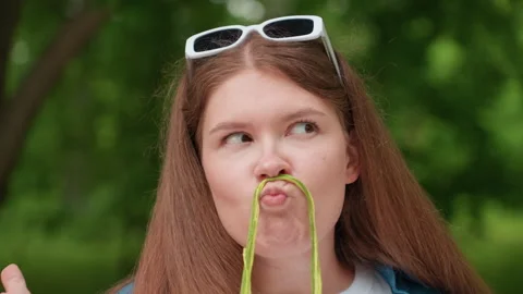 Funny Student Making Mustache Face with Thread While Turning Eyes Outdoors Stock Footage 328354574