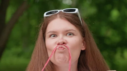 Funny Student Making Mustache Face with Pink Thread While Turning Eyes Stock Footage 330598881