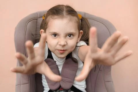 Funny studio portrait of a strapped child in a car seat Stock Photos