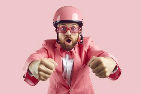 Funny surprised and scared man in pink helmet steering driving his invisible car Stock Photos