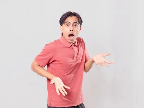 Funny surprised face expression of Asian man looking at camera, isolated on.. Stock Photos