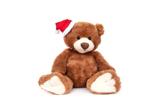 Funny teddy bear with small shiny Santa Claus hat on white xmas Stock Photos
