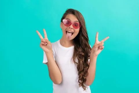 Funny teen girl long curly hair in sunglasses casual style on blue background Stock Photos