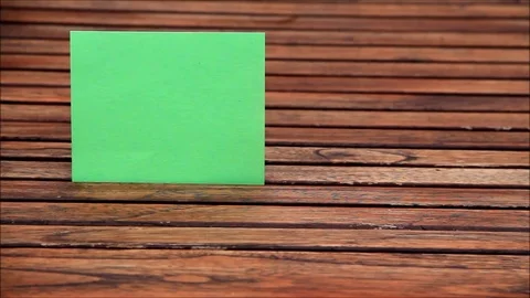 Funny texture paper, green square paper comes through a wood table Stock Footage 76094714