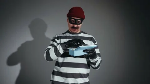 A funny thief in mask and Prison Uniform kidnapped jeweler box Stock-Footage 224530556