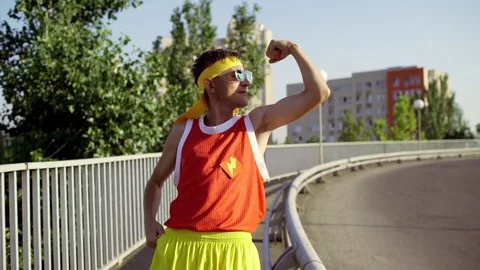 Funny thin man freak is happy after training in the city park Stock Footage 79078803