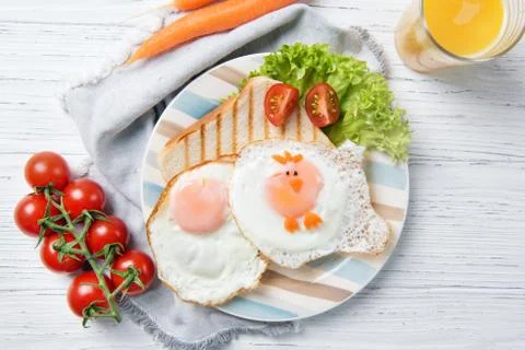 Funny toast with fried eggs in a shape of chicken, healthy food for kids Stock Photos