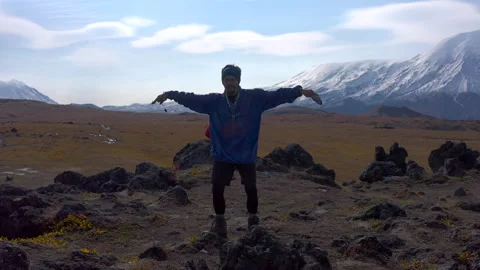 A funny tourist is dancing in the mountains 库存影片 142931343