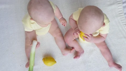 Funny Twin Babies Playing With Fresh Fruits And Vegetables. Video stock 134199170