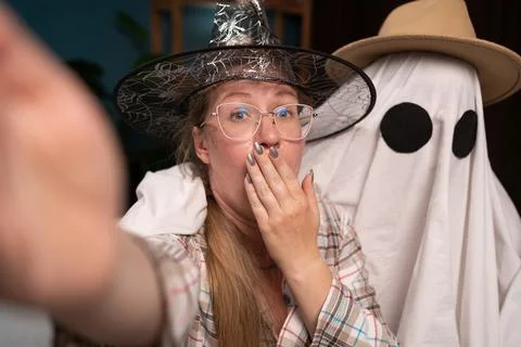 Funny two people man in ghost costume and shocked woman in witch hat with Stock Photos