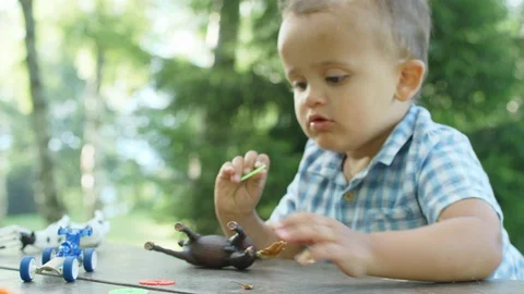 Funny two years boy playing on the table outside, the picnic area of the park Vídeo Stock 98567916