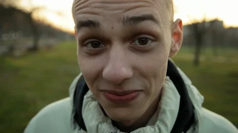 Funny wide angle closeup portrait of aping man in the park in the evening Видео 121061582