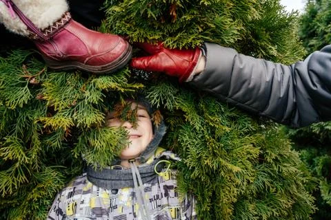 Funny winter composition a boy in a hat, a female hand and a children's red boot Stock Photos