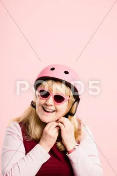 Funny woman wearing cycling helmet portrait pink background real people high Stock Photos