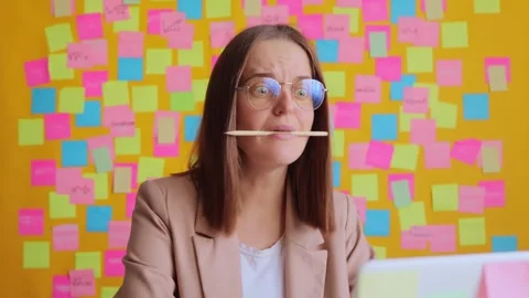 Funny woman working on laptop computer at her workplace with multicolored memo Stock Footage 255791853