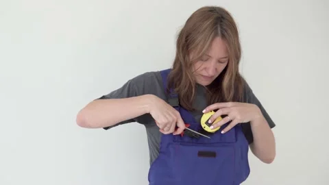 Funny woman in a working suit with a centimeter, flat-hoods and screwdriver Stock Footage 155298002