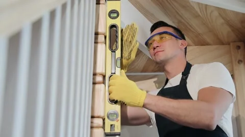 Funny worker joking, carpenter with sense of humor checks the level of stairs Stock Footage 133429960