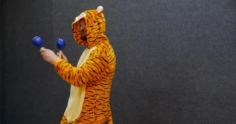 Funny worker in open space wearing kigurumi, tiger pajama clothing and playing Stock Footage 106082674