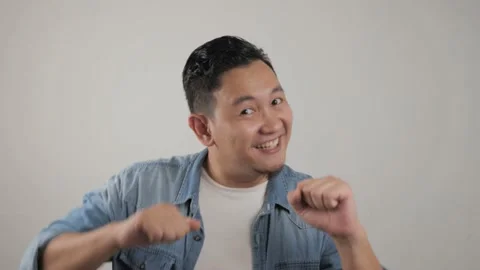 Funny young Asian man dancing happily joyful expressing celebrating good news Stock Footage 143762140