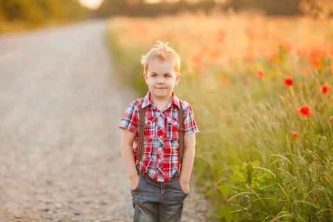 A funny young boy with eye misalignment, smiling and giggling in a sunset-lit Stock Photos